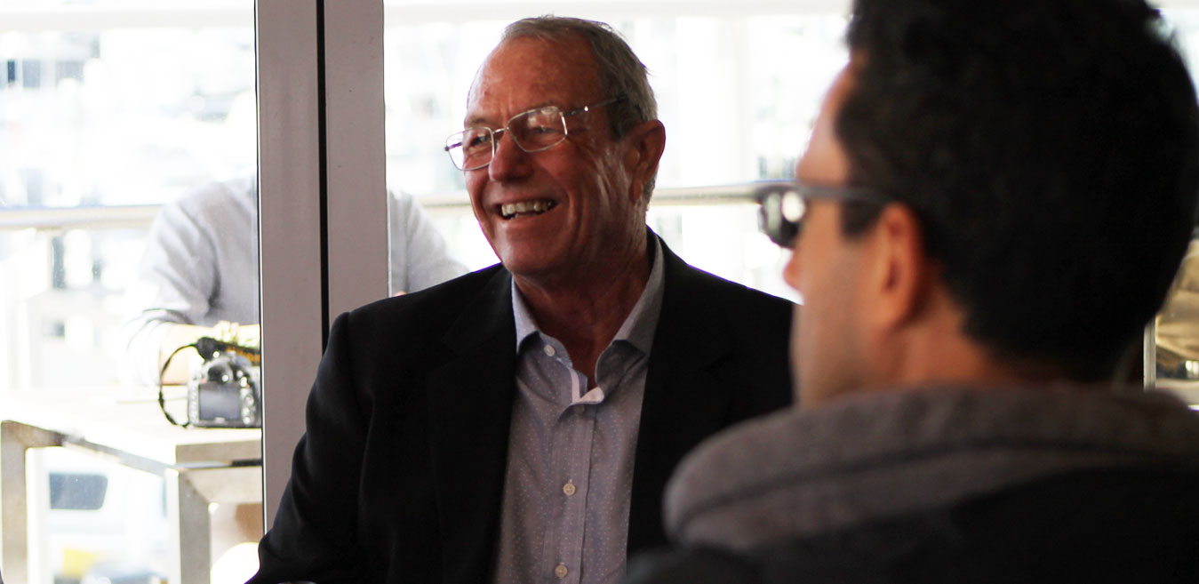 Roger Evans speaking with a participant in a meeting space.